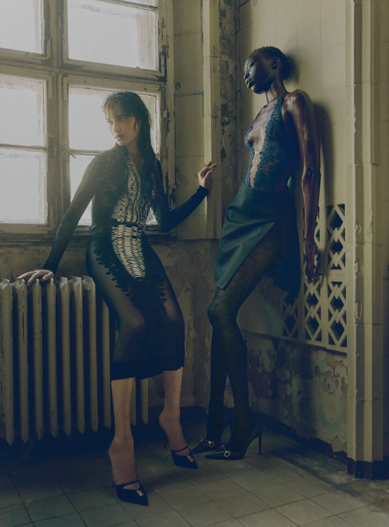Two models posing in a weathered interior with large windows for a V Magazine fashion editorial