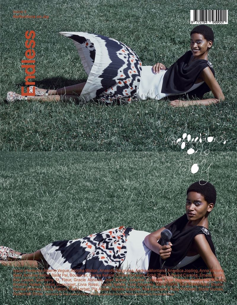 Model lying on lush green grass wearing a patterned skirt and dark top for endless magazine Issue V