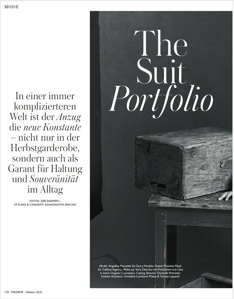 Magazine page spread featuring The Suit Portfolio title with a wooden box on a dark textured background