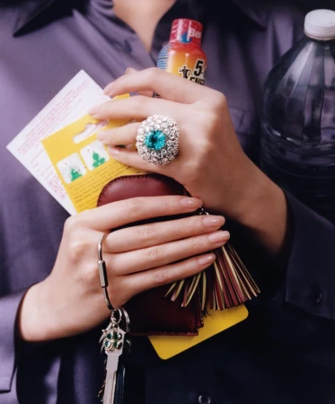 Close-up of hands holding various objects including a large gemstone ring, keys, and a plastic bottle for WSJ by Jackie Kursel