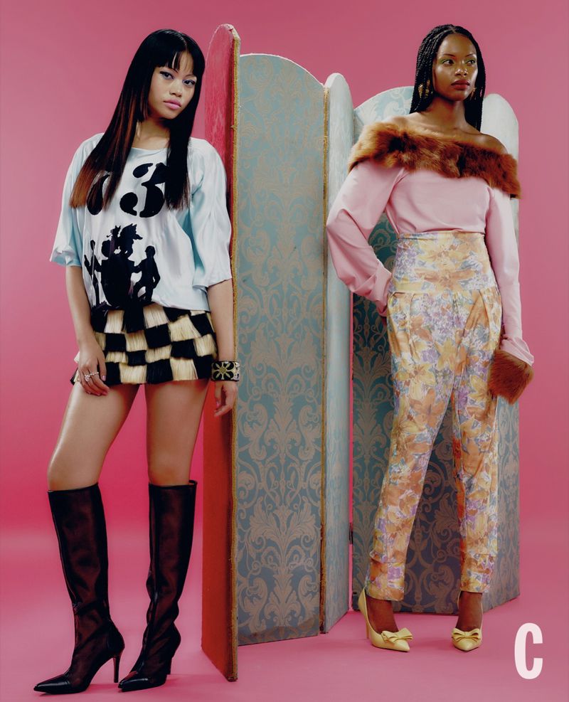 Two female models posing in front of a decorative screen against a solid pink backdrop for Cosmopolitan UK