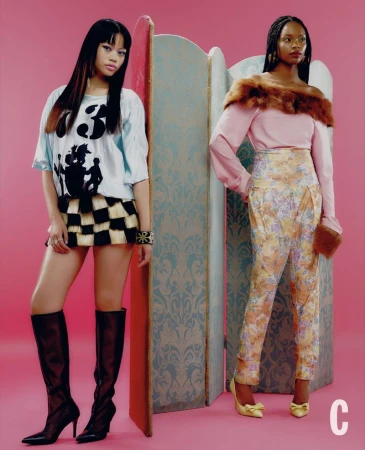 Two female models posing in front of a decorative screen against a solid pink backdrop for Cosmopolitan UK