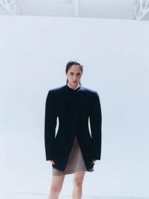 Model Sara Caballero in a dark structured jacket and skirt against a white background for Muse Magazine