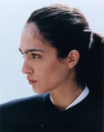 Profile portrait of model Sara Caballero wearing a dark garment with white collar against a seamless light background