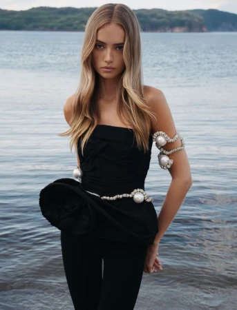 Model Emma Ellingsen wearing a black strapless top with pearl body jewellery by the water for Costume Norway EMMA editorial.