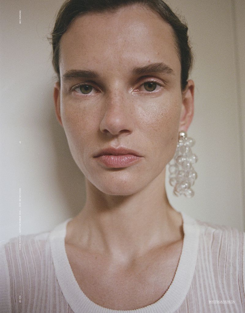 Close-up portrait of model Giedre Dukauskaite wearing a white top and clear beaded earrings for Love Want Magazine.