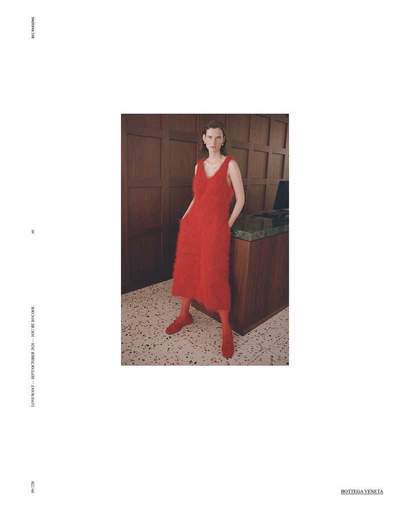 Model Giedre Dukauskaite wearing a bright red dress standing in a wood-paneled interior for Love Want Magazine editorial