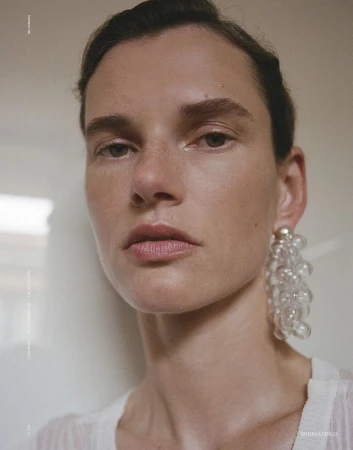 Close-up portrait of model Giedre Dukauskaite wearing statement bubble earrings for Love Want Magazine