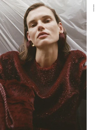 Model Giedre Dukauskaite wearing a textured red sweater against a crinkled white plastic backdrop for Love Want Magazine.