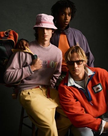Three models wearing colorful apparel including a pink bucket hat and orange fleece for Zara by photographer Luis Alberto Rodriguez.