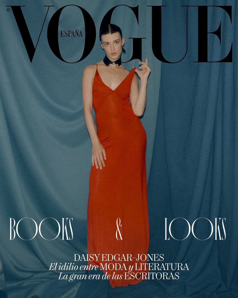 Daisy Edgar-Jones in a red dress standing against draped teal fabric background for Vogue Espana