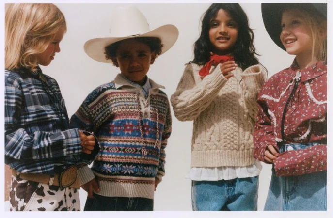 Four children in Western-inspired clothing posing together against a plain light background in an editorial fashion photograph.