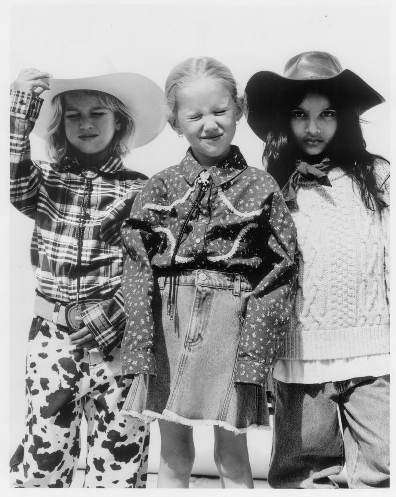 Three young models in western-inspired clothing posing outdoors in black and white photography.