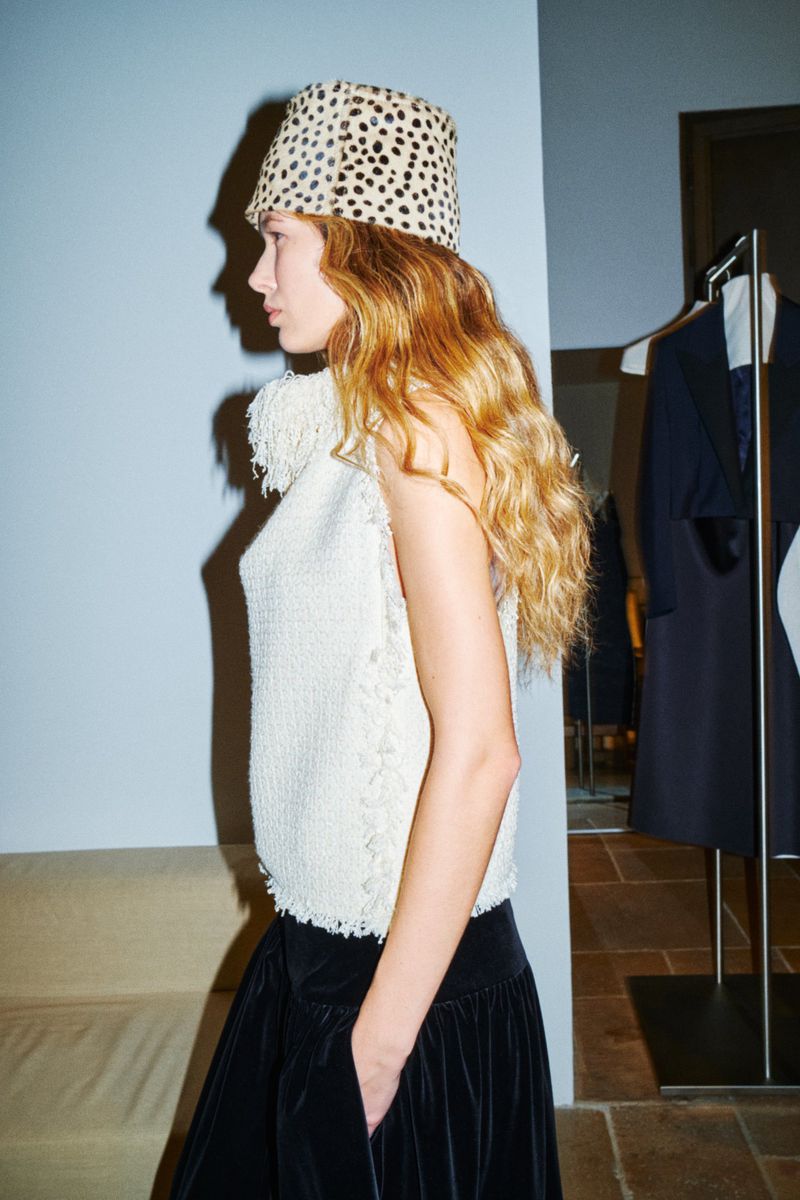 Model in profile wearing an animal-print bucket hat and textured white top for American Vogue
