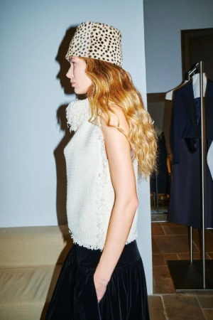 Model in profile wearing an animal-print bucket hat and textured white top for American Vogue