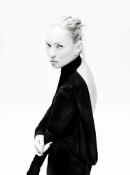 Portrait of model Kate Moss wearing a black long-sleeve top against a white seamless background for The Perfect Magazine.