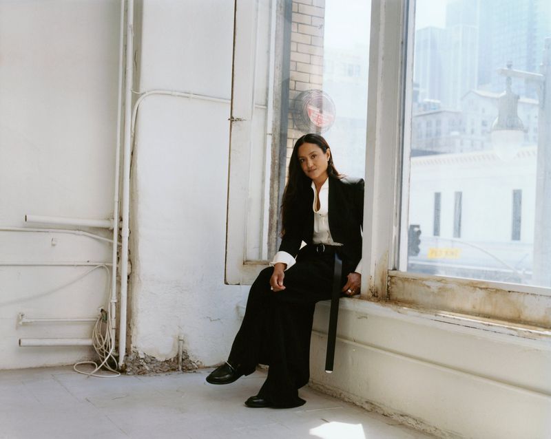 Autumn Durald Arkapaw seated on a windowsill wearing a black suit and white shirt for The Gentlewoman portrait.
