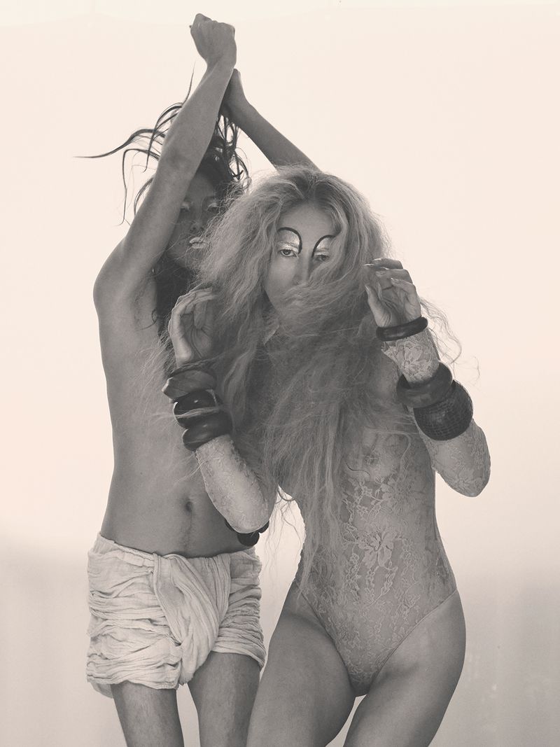 Model Raquel Zimmermann posing alongside another figure in a monochrome fashion editorial for W Magazine.
