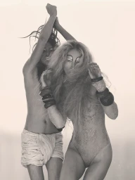 Model Raquel Zimmermann posing alongside another figure in a monochrome fashion editorial for W Magazine.