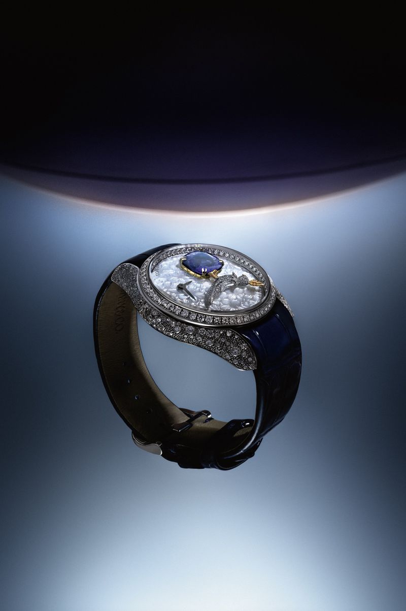 Luxury diamond-encrusted wristwatch with blue strap on gradient blue background for Orbital project by Nu Icons