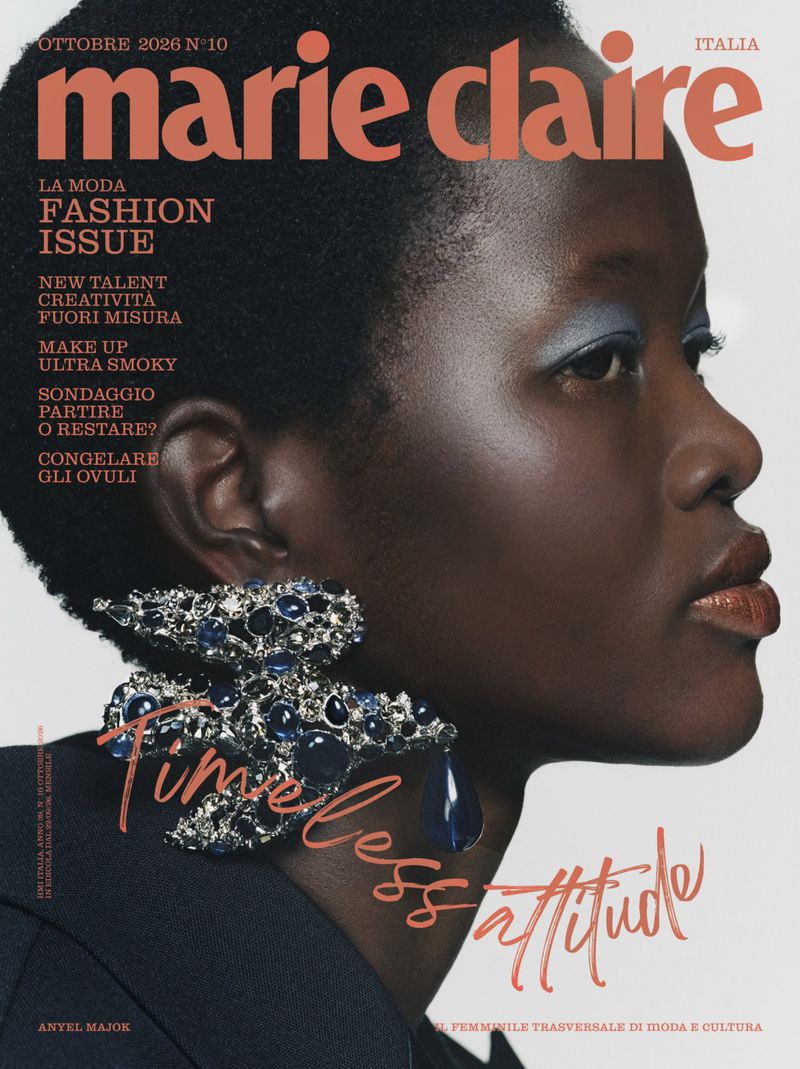 Close-up profile portrait of a black woman wearing a large jeweled earring and blue eyeshadow for a magazine cover
