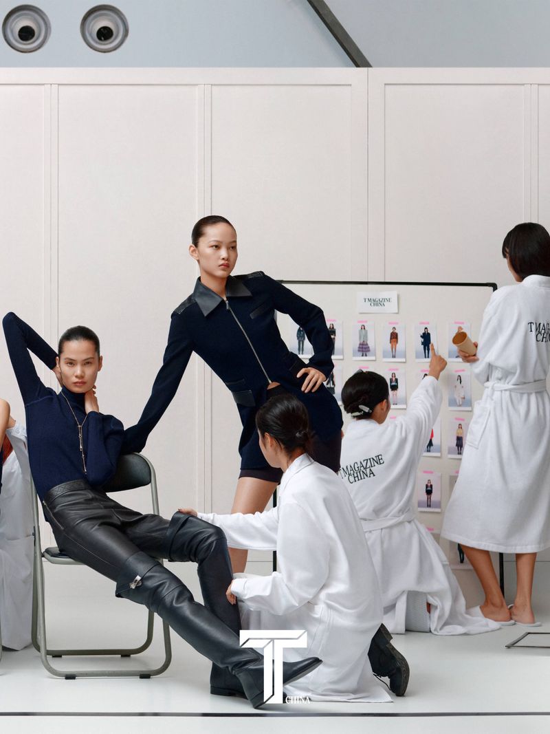 Models and crew in white robes gathered around a mood board for T Magazine China photo shoot by Liu Song