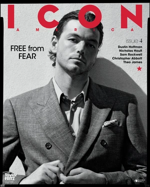 Portrait of tennis player Taylor Fritz wearing a grey double-breasted suit against a textured wall for ICON America magazine cover.