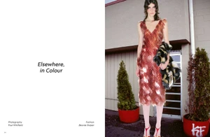 Model in a red sequined dress standing outdoors holding a patterned bag between potted trees for Heroine Magazine