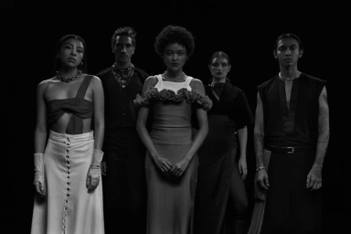 Five models posing together in black and white attire against a dark background for Revista 192 Latitud fashion project