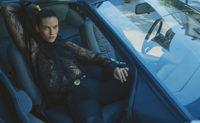 Model Beauïse Genç seated in a convertible car wearing a black lace top shot by Gregory Harris for Elle France.