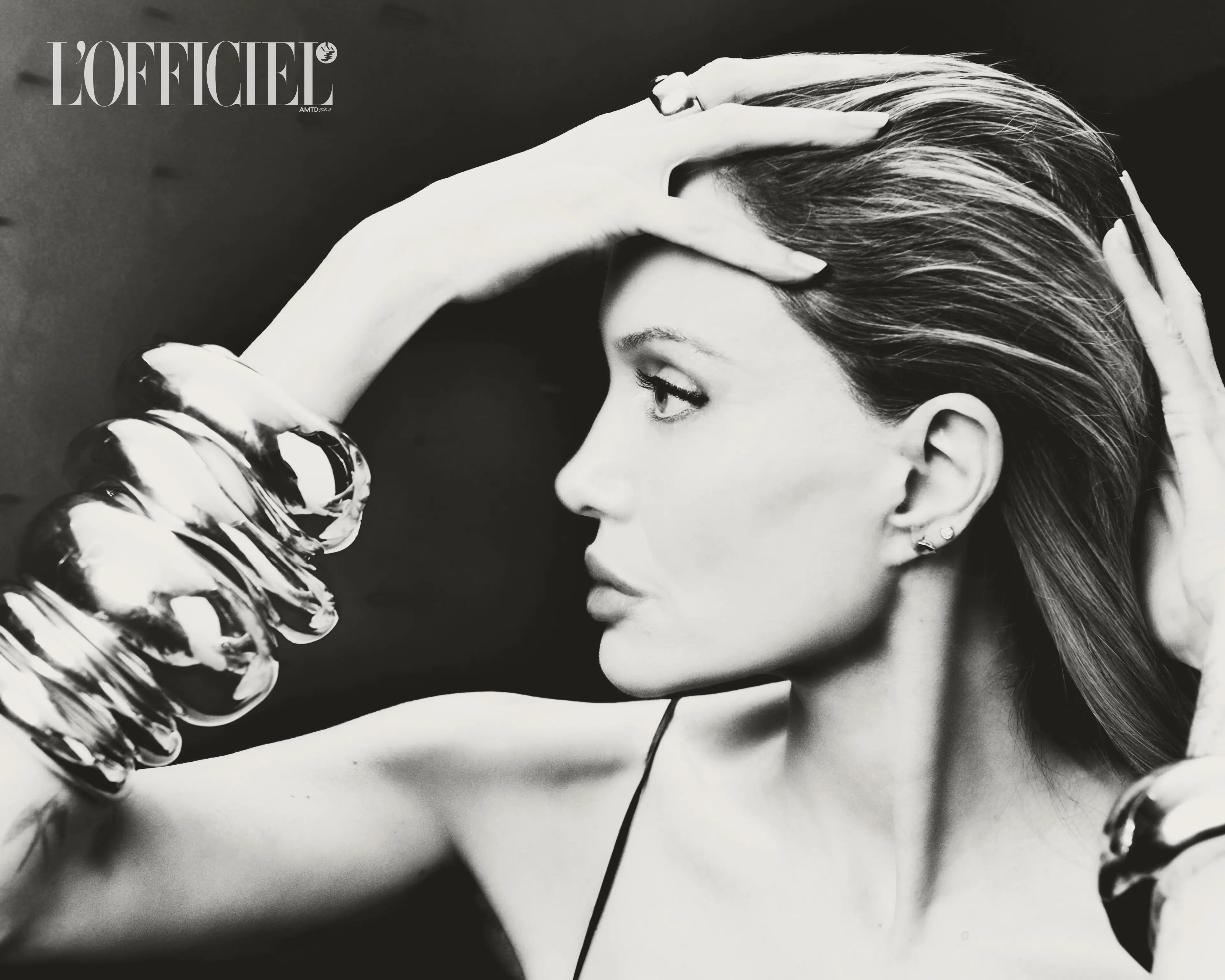 Monochrome portrait of Angelina Jolie wearing large metallic statement bracelets for L'Officiel Italia