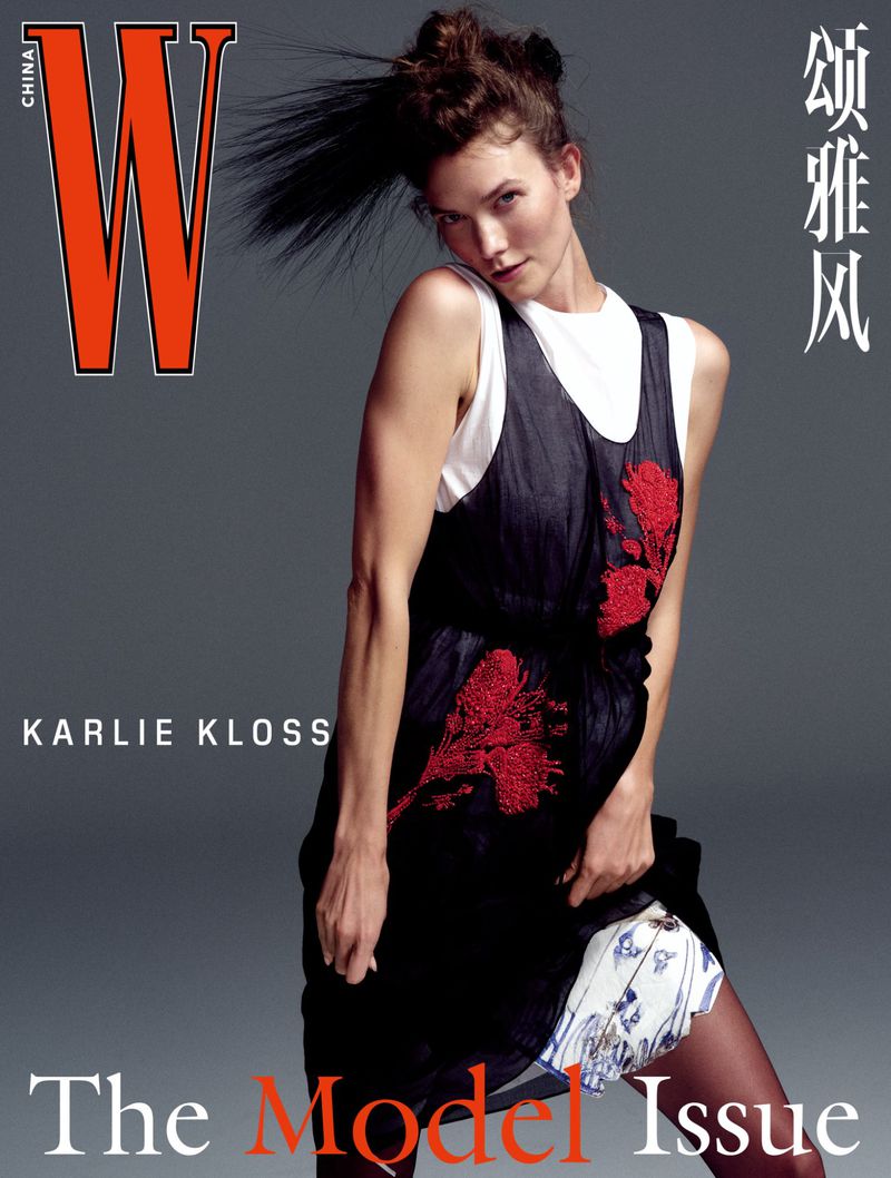 Model Karlie Kloss posing in a black dress over a white top against a grey studio backdrop for W Magazine China.