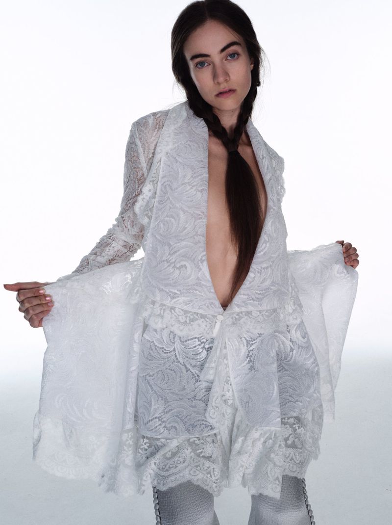 Grace Hartzel in a white lace jacket holding out the sides against a white background for Pop Magazine
