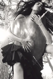 Model holding a metallic sheet outdoors among trees for Pop Magazine, photographed by Oliver Hadlee Pearch.