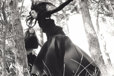 Model Grace Hartzel in black clothing posing mid-air among trees for Pop Magazine, photographed by Oliver Hadlee Pearch.
