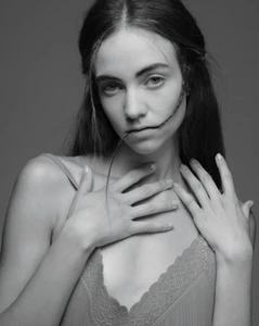 Monochrome portrait of Grace Hartzel with hands near her chest biting a strand of hair for Pop Magazine editorial.