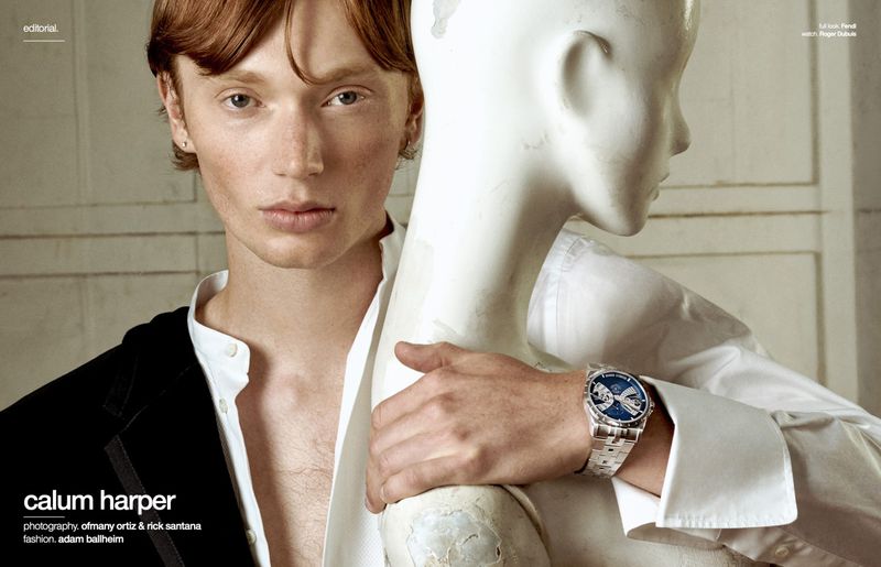 Close-up portrait of a male model with red hair posing next to a white mannequin wearing a luxury wristwatch