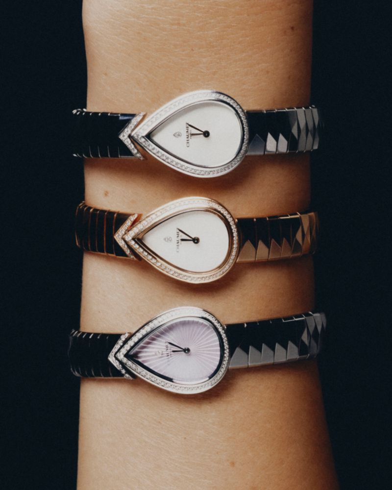 Close-up of a wrist wearing three teardrop-shaped luxury wristwatches against a dark background.