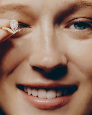 Close-up portrait of a woman holding a diamond ring up to her eye for Mixte project In the Shadows