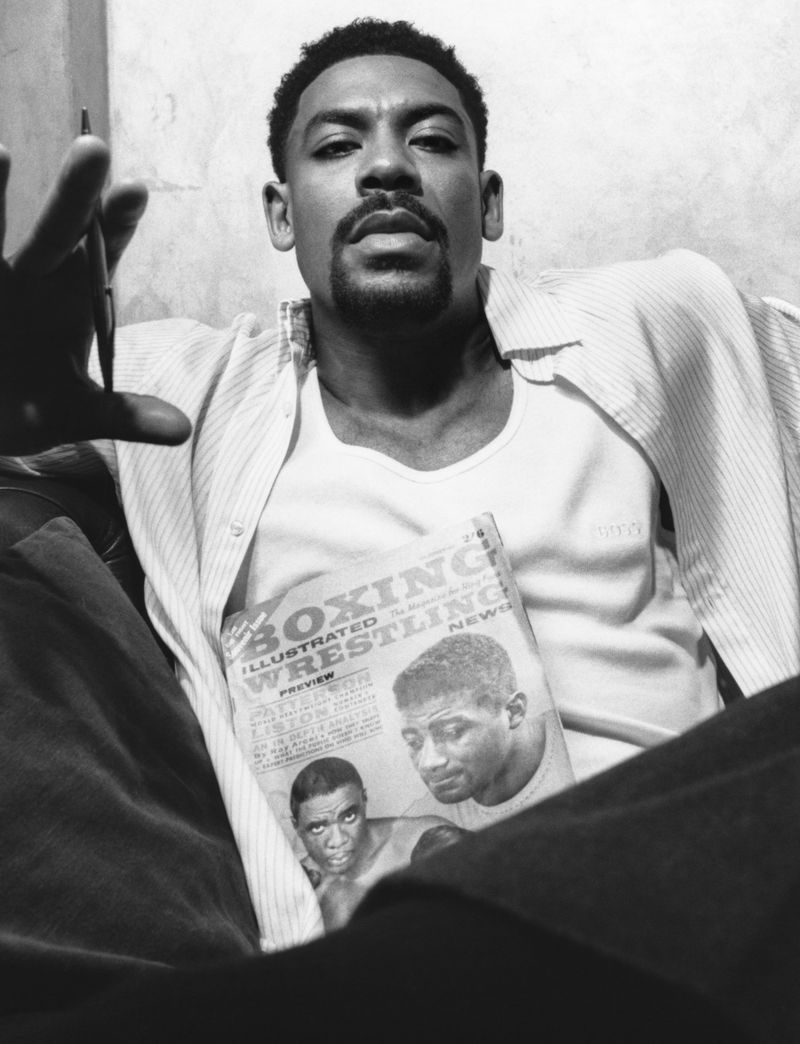 Black and white portrait of actor Aaron Pierre holding a vintage boxing magazine in HERO Magazine editorial.