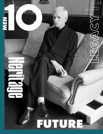 Jay Jay Johanson seated on a patterned sofa wearing a dark suit for 10 Men Magazine