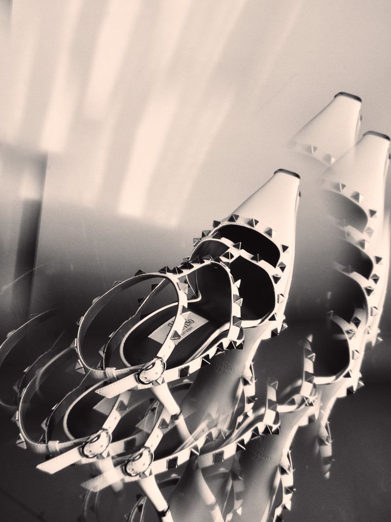 Close-up angled shot of studded strapped high-heel shoes with a dreamy soft-focus overlay effect.