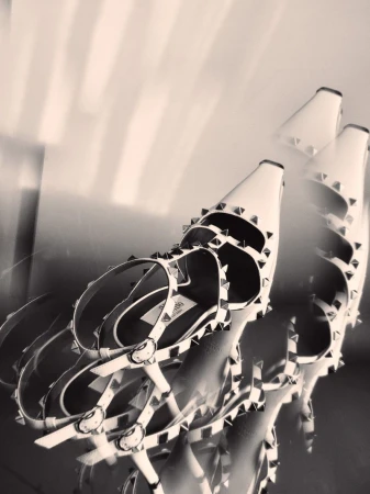 Close-up angled shot of studded strapped high-heel shoes with a dreamy soft-focus overlay effect.