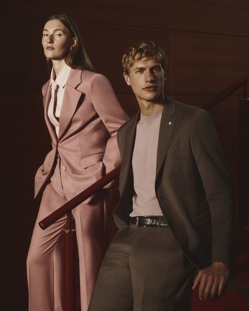 Two models wearing tailored suits on a wooden staircase for the Manuel Ritz FW26 campaign, photographed by Gautier Pellegrin.