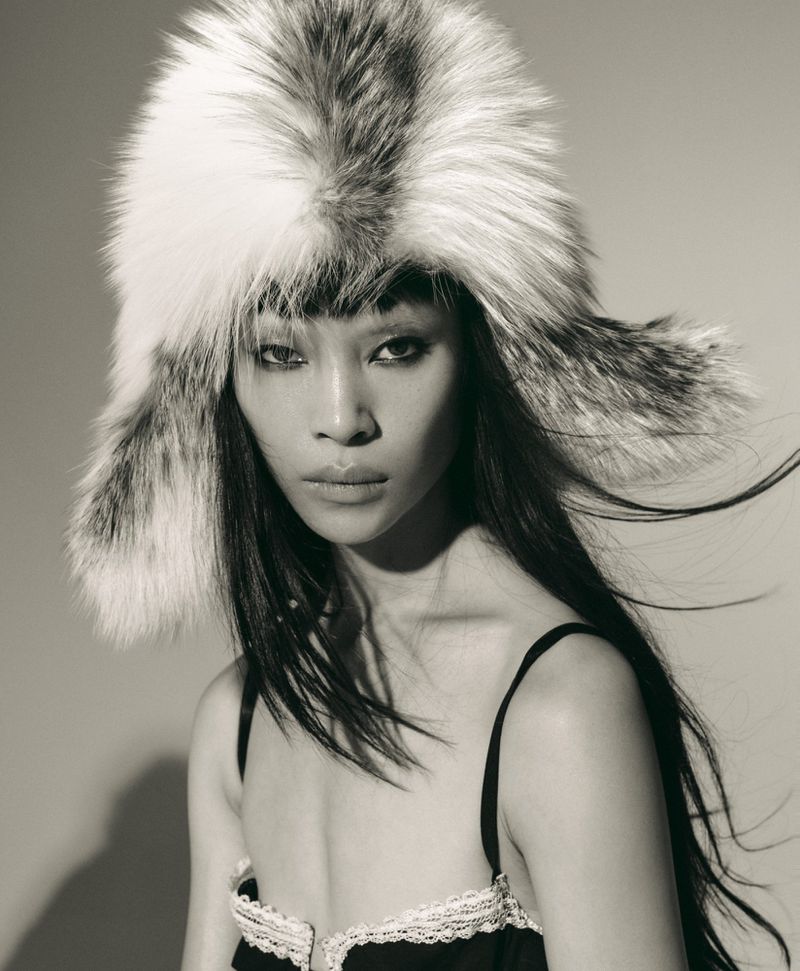 Close-up portrait of model Diane Chiu wearing a large fluffy fur ushanka hat and black lingerie top for Rouge Fashionbook.