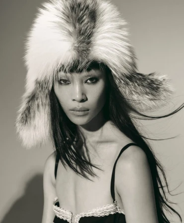 Close-up portrait of model Diane Chiu wearing a large fluffy fur ushanka hat and black lingerie top for Rouge Fashionbook.