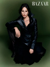 Model Taleedah Tamer wearing a black leather jacket against a dark green studio backdrop for Harper's Bazaar Arabia.