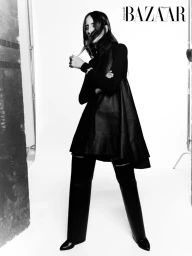 Model Taleedah Tamer wearing a black dress and boots in a studio shoot for Harper's Bazaar Arabia