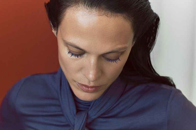 Close-up portrait of model Aymeline Valade wearing a blue top with bright blue mascara for M Le magazine du Monde editorial.