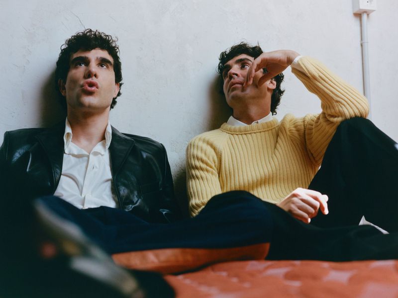 Two men leaning against a textured white wall for an i-D Magazine feature photographed by Javier Ruiz.